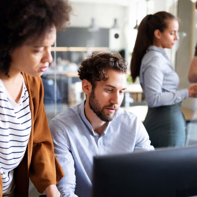 A man and woman working together looking at a laptop