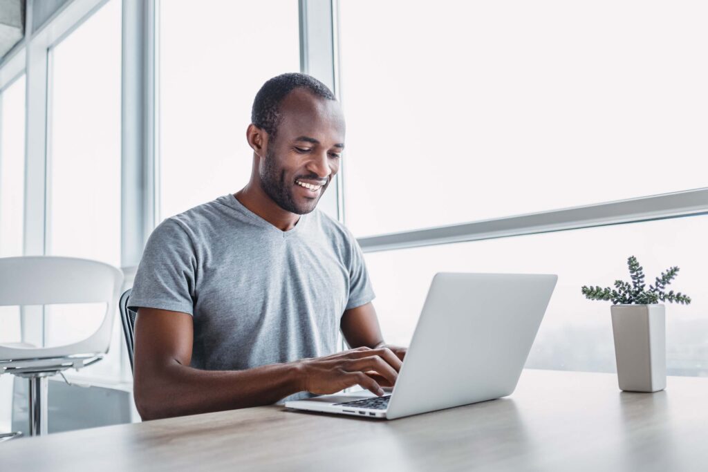 A man sitting at a desk working on his laptop.