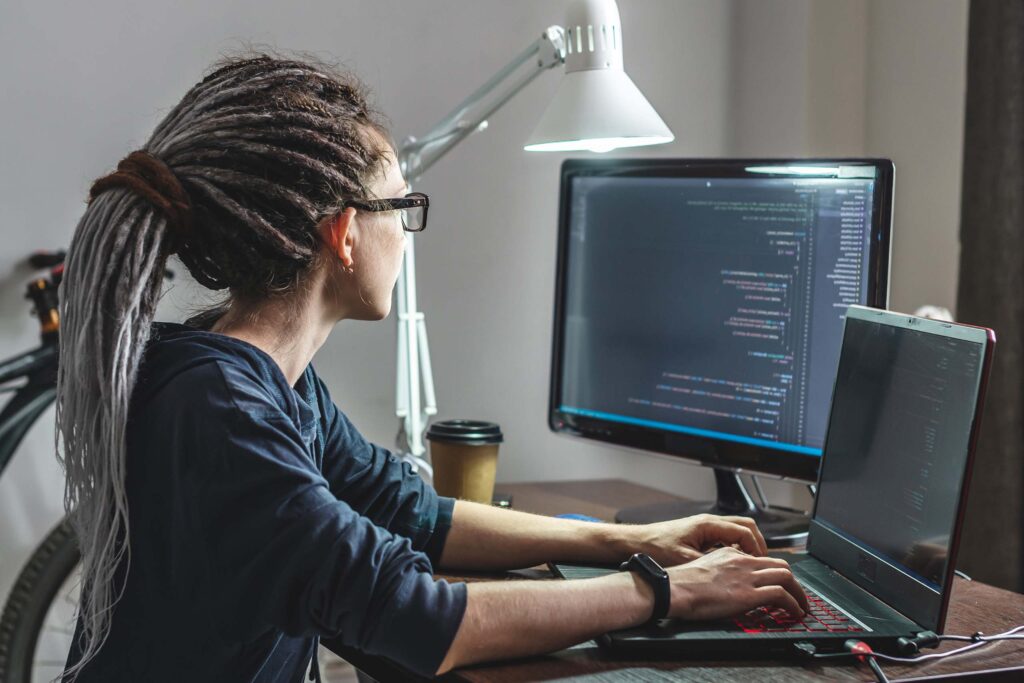 A woman sitting at her desk looking at a computer.